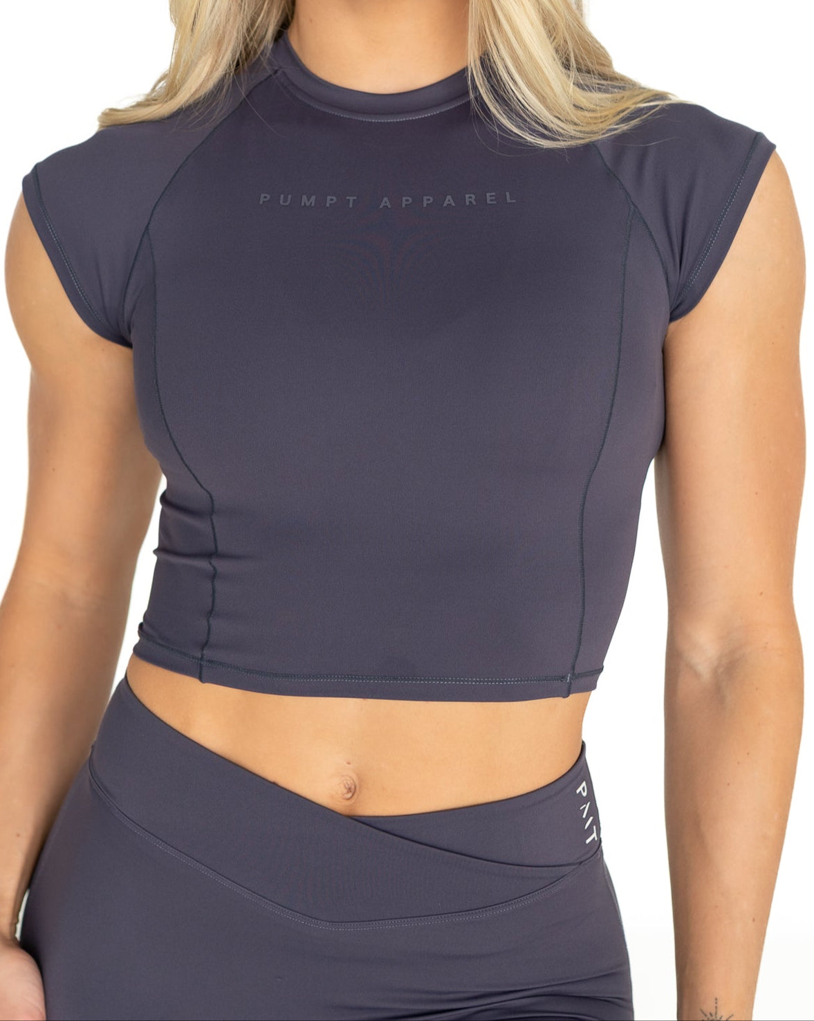 Woman wearing a dusk purple athletic outfit with 'Pumpt Apparel' branding on a white background