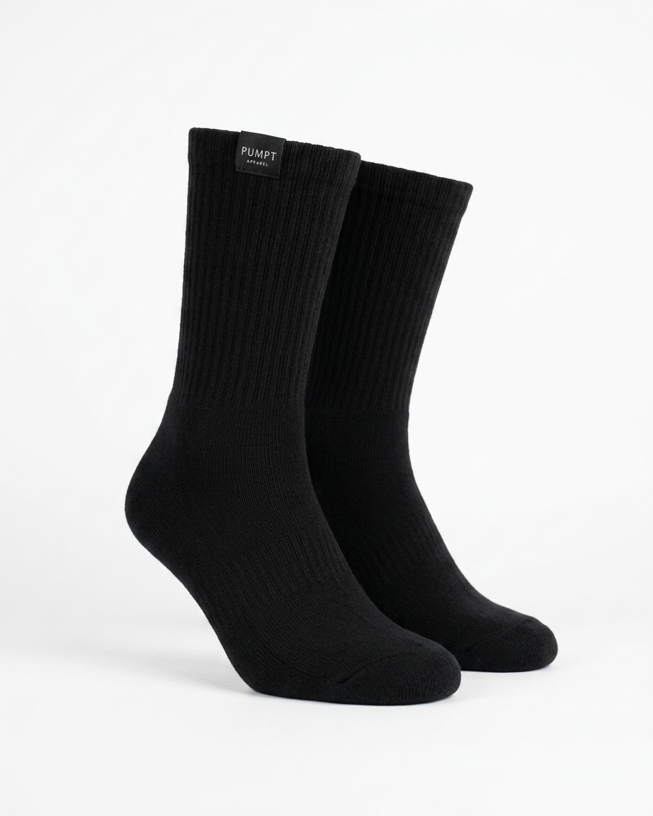 A pair of black ribbed crew socks displayed on invisible forms against a clean white background. The brand name 'PUMPT Apparel' is visible on a small black label at the top cuff.