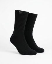 A pair of black ribbed crew socks displayed on invisible forms against a clean white background. The brand name 'PUMPT Apparel' is visible on a small black label at the top cuff.