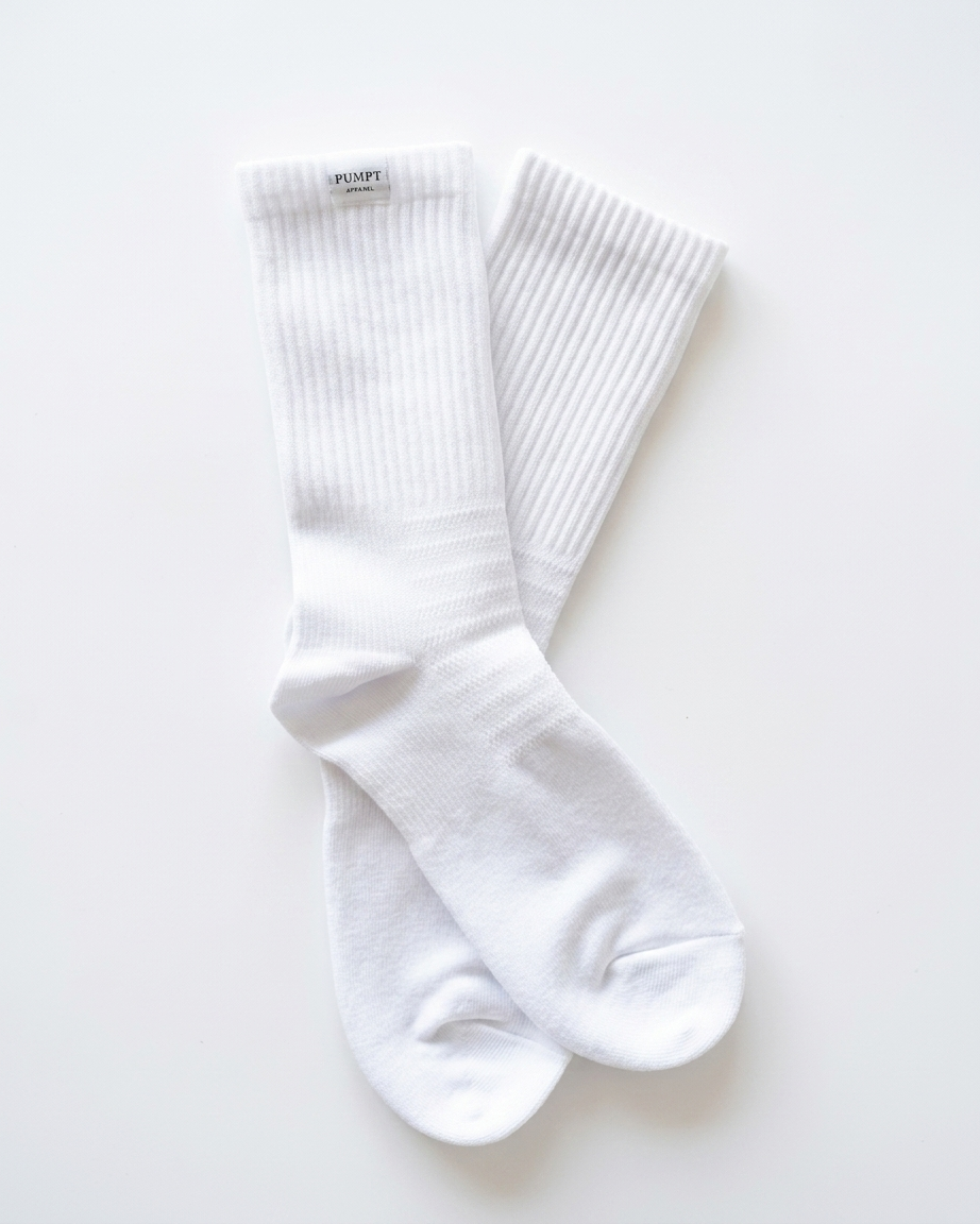 A pair of white ribbed Pumpt Apparel crew socks laid flat on a clean white background.