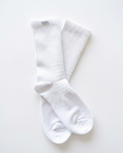 A pair of white ribbed Pumpt Apparel crew socks laid flat on a clean white background.