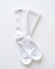 A pair of white ribbed Pumpt Apparel crew socks laid flat on a clean white background.