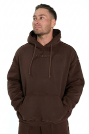 Man wearing a brown hoodie and pants with 'PUMPT' branding on a white background